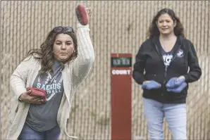  ?? Chris Torres/ The Signal ?? (Above) Patty Moreno (left) and Heidi Stauffer compete against each other in a cornhole game. (Right) Saugus High School softball assistant coach Mike Dockery watches his bean bag fly across the court.