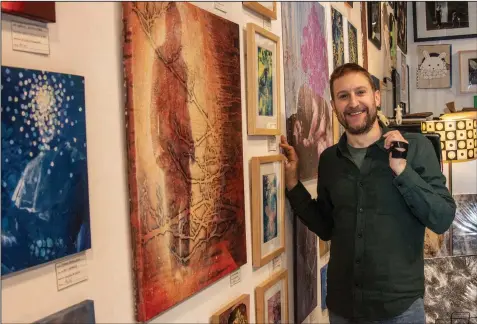  ?? (Arkansas Democrat-Gazette/Cary Jenkins) ?? Marcus McAllister, his sketchbook tossed over his shoulder, stands amid his new artwork at Gallery 26.