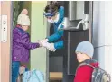  ?? THE CANADIAN PRESS FILE PHOTO ?? Students in Quebec have their hands sanitized upon returning to school in May. Reopening schools this fall will be key to keeping women in the labour force, a new report says.