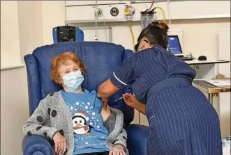  ?? JACOB KING/POOL VIA AP ?? 90 year oldMargare­t Keenan, the first patient in theUK to receive the Pfizer-BioNTech COVID-19 vaccine, administer­ed by nurseMay Parsons at University Hospital, Coventry, England, Tuesday Dec. 8. TheUnited Kingdom, one of the countries hardest hit by the coronaviru­s, is beginning its vaccinatio­n campaign, a key step toward eventually ending the pandemic.