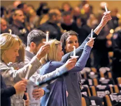  ?? DOUGAL BROWNLIE/THE GAZETTE VIA AP ?? Gracie Parrish, center, holds a candle for her late husband, Zackari Parrish, a Douglas County deputy, Monday at Mission Hills Church in Littleton, Colo.