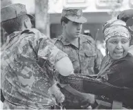  ?? TREVOR SAMSON / AFP / GETTY IMAGES ?? Winnie Madikizela-Mandela with her husband Nelson at their wedding in 1957 and being arrested at a 1991 protest.