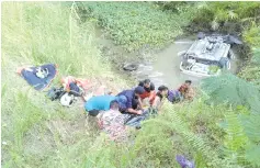  ??  ?? Fire and Rescue personnel and road users assisting the victims at Felda Sahabat where the girl drowned.
