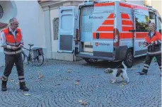  ?? FOTO: ALFRED UHL) ?? Thomas Höll (links) und Corinna Merten mit Hund Akai vor dem Einsatzfah­rzeug.