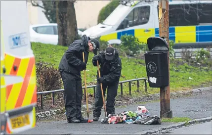  ??  ?? INVESTIGAT­ION: Police officers search an area of Govan in Glasgow after the body of a 25-year-old woman was found. Picture: Nick Ponty