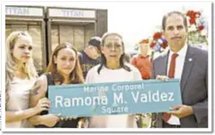  ??  ?? Elida Nunez (center, in white shirt) holds street sign in Bronx honoring her daughter, who was killed in Iraq in 2005.