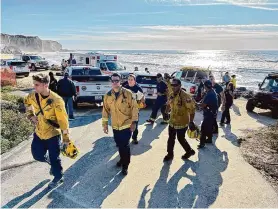  ?? Loren Elliott/Special to the Chronicle ?? A rescue crew works at Martins Beach in Half Moon Bay after a 5-year-old girl and 54-year-old man were swept into the ocean Saturday. The girl was rescued, but the man remains missing.
