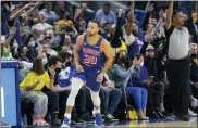  ?? JEFF CHIU — THE ASSOCIATED PRESS ?? Golden State Warriors guard Stephen Curry (30) reacts in front of fans after shooting a 3-point basket against the Phoenix Suns during the first half of Friday’s game in San Francisco.