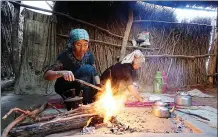  ??  ?? Women make a fire to cook in Daiyabuli township.