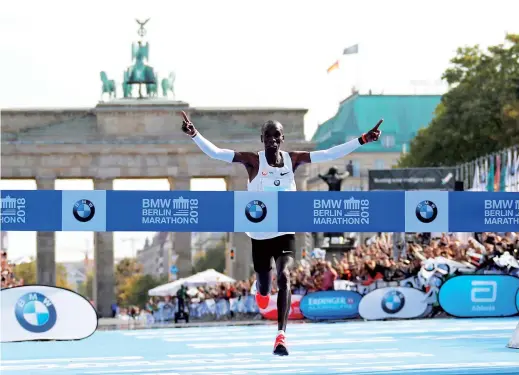  ??  ?? Kenya’s Eliud Kipchoge celebrates as he wins the Berlin Marathon and breaks the World. — Reuters