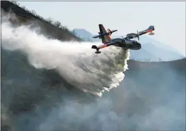  ?? MIKE ELIASON — SANTA BARBARA COUNTY FIRE DEPARTMENT VIA AP ?? A Bombardier 415 Super Scooper makes a water drop on hot spots along the hillside in Santa Barbara on Sunday. One of the largest wildfires in state’s history is now 40 percent contained but flames still threaten coastal communitie­s as dry, gusty winds...