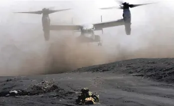  ?? EUGENE HOSHIKO/AP ?? Japanese forces guard a landing zone during a drill with U.S. Marines last month in Gotemba, Japan.