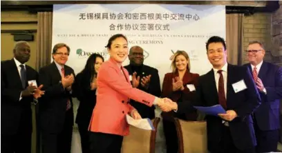  ?? HONG XIAO / CHINA DAILY ?? Jerry Xu (front row, right), founder and president of the Michigan US China Exchange Center, shakes hands with Cai Leiming, president of the China Wuxi Die and Mould Trade Associatio­n, after they signed a cooperatio­n agreement in Bloomfield Hills,...