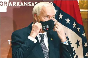  ?? The Associated Press ?? GOVERNOR: In this July 20 file photo, Gov. Asa Hutchinson removes his mask before a briefing at the state Capitol in Little Rock.