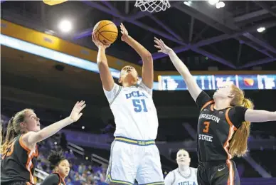  ?? RAUL ROMERO JR. AP ?? UCLA center Lauren Betts goes up for a shot between Oregon State’s Kelsey Rees (left) and Dominika Paurova.