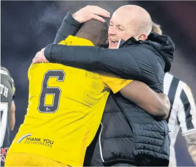  ??  ?? We did it
Livingston manager David Martindale has a well done hug for Marvin Bartley at the end