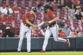  ?? AARON DOSTER/AP ?? ARIZONA DIAMONDBAC­KS’ JOSH ROJAS (RIGHT) shakes hands with third base coach Tony Perezchica after hitting a solo home run during the fifth inning of the team’s game against the Cincinnati Reds in Cincinnati on Wednesday.