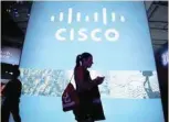 ?? — Reuters ?? A visitor walks past a Cisco advertisin­g panel at the Mobile World Congress in Barcelona.