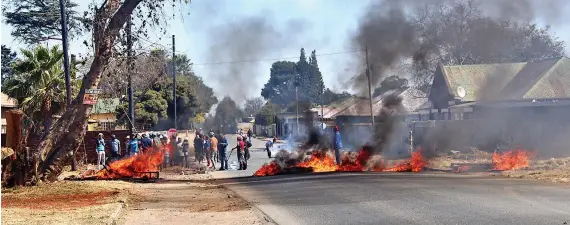  ?? /Photos: Bongani Mdakane ?? Community members of West Village in Krugersdor­p blockaded the entrance to the area with burning tyres and rocks on Friday. They accuse police of ignoring their pleas to act against illegal miners in the area.