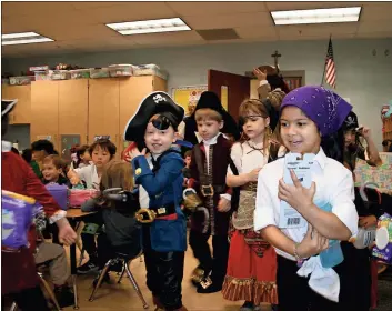  ?? / John Popham ?? Pirate kindergart­ners plunder a pre-k classroom Friday morning at Saint Mary’s Catholic School. The marauders were snatching up items such as diapers, wipes and toiletries to give to the Ruth and Naomi Project.