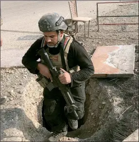  ?? AP/ ALI ABDUL HASSAN ?? A soldier with Iraq’s elite counterter­rorism force on Thursday inspects a tunnel dug by Islamic State militants in Bartella, Iraq.