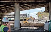  ?? David Goldman / The Associated Press ?? Constructi­on crews work on a section of an overpass that collapsed from a large fire on Interstate 85 in Atlanta.