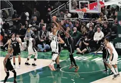  ?? BOBBY ARIFIN/JAWA POS ?? LANGSUNG JADI MVP: Dua pemain Brooklyn Nets mengeblok Giannis Antetokoun­mpo (tengah) yang hendak melepaskan tembakan.