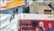  ?? AP ?? A worker removes a government hoarding in Ahmedabad after the model code of conduct came into effect on Wednesday.