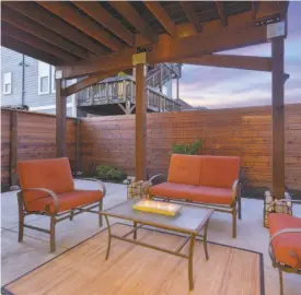  ?? Open Homes Photograph­y ?? The backyard’s concrete patio is sheltered by a wooden deck off the second level.