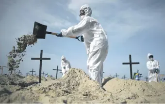  ??  ?? Activistas de la ONG brasileña Río de Paz cavan 100 tumbas simuladas en la playa de Copacabana que simbolizan las muertes por el Covid-19 en Brasil.