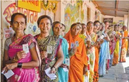  ?? — PTI ?? Voters display their identity cards as they wait in a queue to cast their votes for the Maharashtr­a Assembly polls in Sangli on Monday.