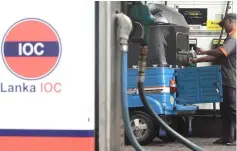  ??  ?? A worker fills the tank of a motorised vehicle, at a Lanka IOC station in Colombo. Sri Lankan fuel retailer Lanka IOC raised retail prices for gasoline and diesel, the company said, due to losses incurred after the government’s failure to implement a...