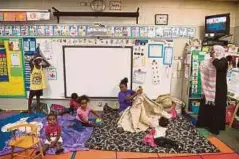  ??  ?? SEORANG wanita dan anak-anaknya bersedia tidur di bilik darjah yang menjadi tempat perlindung­an mereka sehingga Taufan Irma berlalu di Tampa, Florida. - AFP