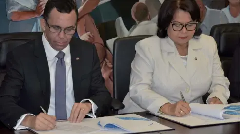  ?? F. EXTERNA ?? El ministro de Educación, Andrés Navarro, y la rectora de la UASD, Emma Polanco, firman el convenio.