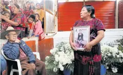  ?? ?? TRAIL OF TRAGEDY: Tomasa Us holds a photo of her son Wilson Ramos during a funeral on Friday for migrants who died in a trailer accident in southern Mexico.