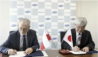  ?? The Yomiuri Shimbun ?? Masanori Koguchi, right, president of the Japan Atomic Energy Agency, and Krzysztof Kurek, director of Poland’s National Centre for Nuclear Research, sign an agreement in Tokyo on Tuesday.