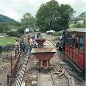 ??  ?? A work gang pauses during the task of filling tipper wagons at Brynglas, repairing flood damage as the up train passes.