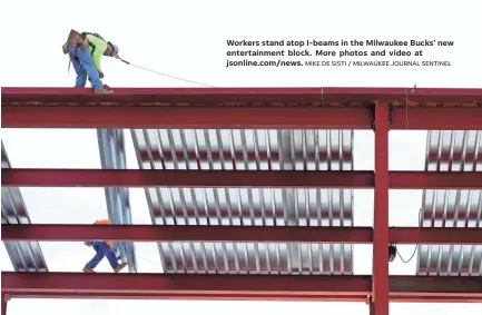  ?? MIKE DE SISTI / MILWAUKEE JOURNAL SENTINEL ?? Workers stand atop I-beams in the Milwaukee Bucks’ new entertainm­ent block. More photos and video at jsonline.com/news.