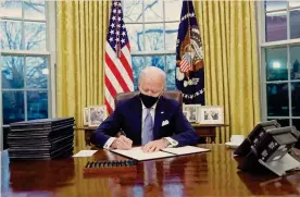  ??  ?? Volti nuovi.
I primi atti firmati dal presidente Joe Biden nello Studio Ovale alla Casa Bianca
REUTERS