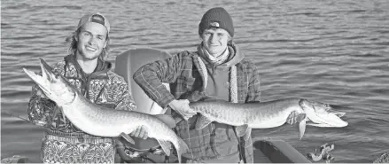  ?? ERIK LENNARTZ ?? Luke Konson, left, and Daniel Balserak, both 18 and from Oakton, Virginia, hold muskies caught on Pewaukee Lake while fishing with guide Erik Lennartz of Oconomowoc. The men are on a "Fish All Fifty" quest to catch the official state fish in each state.