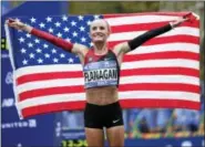  ?? SETH WENIG — THE ASSOCIATED PRESS ?? Shalane Flanagan of the United States poses for pictures after crossing the finish line first in the women’s division of the New York City Marathon in New York, Sunday.