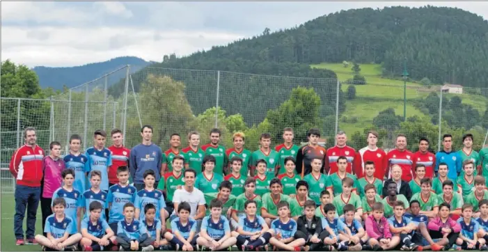  ??  ?? TODO UN EJEMPLO. Los niños del club vizcaíno posan en el campo gernikarra de Urbieta, donde acostumbra­n a disputar sus partidos como locales, en un paraje idílico para la práctica del fútbol co