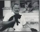  ?? PBS ?? Ernest Hemingway, holding one of his many feline friends, is seen at his home in Cuba in the 1950s in an image included in Ken Burns’ new documentar­y.