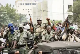  ?? JOHN KALAPO Getty Images ?? Crowds cheer Tuesday as soldiers move through Bamako, Mali.