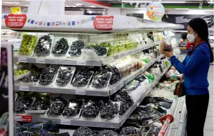  ?? VNA/VNS Photo Trần Việt ?? A woman shops for fresh fruits at a Winmart store in Hà Nội.