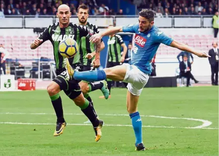  ??  ?? Right on target: Napoli’s Dries Mertens (right) scoring against Sassuolo in the Serie A match at the San Paolo in Naples on Sunday. Napoli won 3-1. — AP