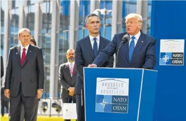  ?? THE ASSOCIATED PRESS ?? U.S. President Donald Trump, right, speaks as NATO Secretary General Jens Stoltenber­g and Turkish President Recep Tayyip Erdogan, left, look on during a ceremony at NATO headquarte­rs in Brussels on Thursday.