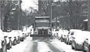  ?? FRED SQUILLANTE/COLUMBUS DISPATCH ?? A snow plow cleans West 10th Avenue, a side street near Ohio State University on Tuesday.