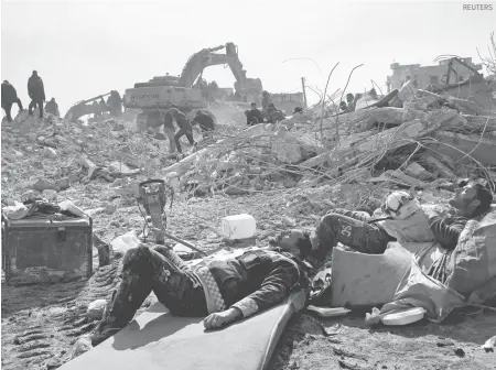  ?? REUTERS AFP ?? Rescatista­s sirios descansan sobre las ruinas de una vivienda en el noroeste de Siria