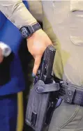 ??  ?? Bernalillo County Sheriff’s deputy Angelina Navarro demonstrat­es how the BodyWorn camera will turn itself on, through a Bluetooth sensor, when she draws her weapon.